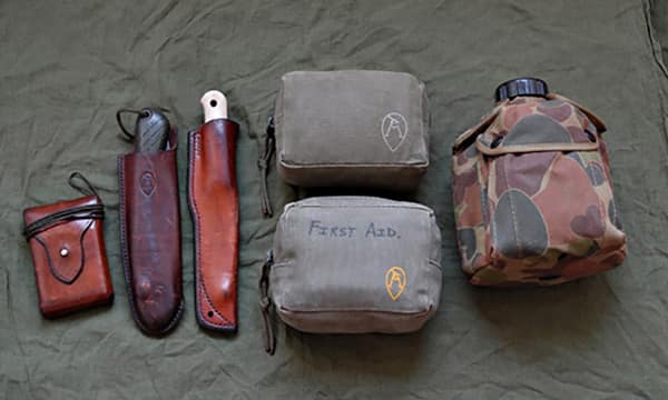 Пример набора для выживания в условиях дикой природы (слева направо): компас, складная пила, нож, НАЗ (верхняя сумка), индивидуальная аптечка для первой помощи в пустыне (нижняя сумка), фляга для воды в комплекте с кружкой.